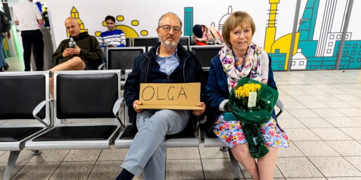 Ukraine hosts holding an arrival sign at an airport