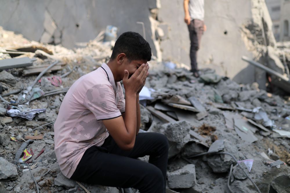 A man cries among the rubble of buildings destroyed in Israeli airstrikes